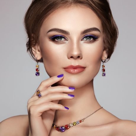 Portrait Beautiful Woman with Jewelry. Model Girl with Violet Manicure on Nails. Elegant Hairstyle. Violet Make-up Arrows. Beauty and Accessories
